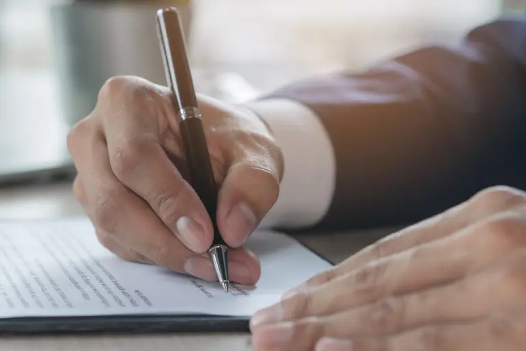 A man signing a contract representing secured loans