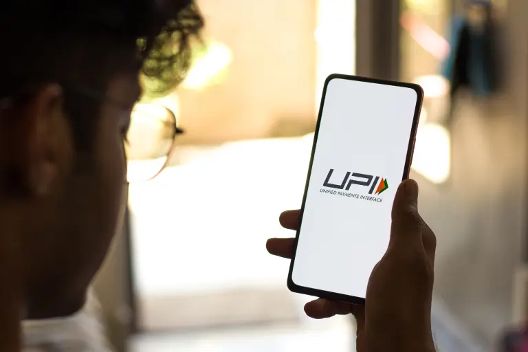 Man looking on phone displayed UPI on mobile screen to check bandhan bank account balance via upi