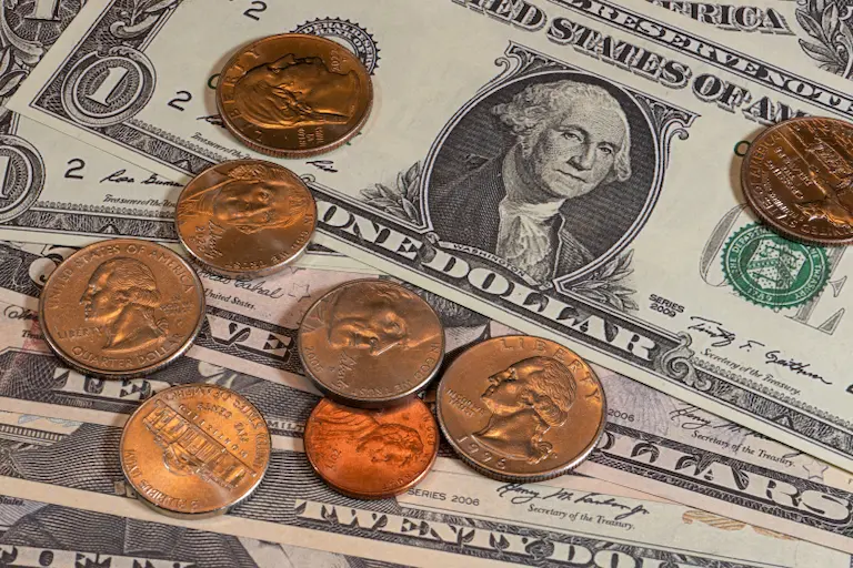 US currency coins and pennies arranged on a US dollar money