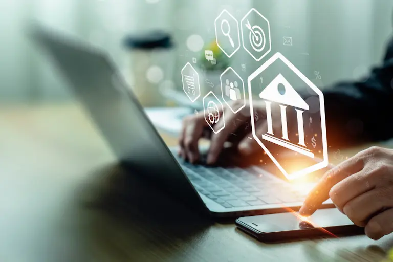 A professional using a laptop with multiple icons visible on the screen means various bank accounts in India