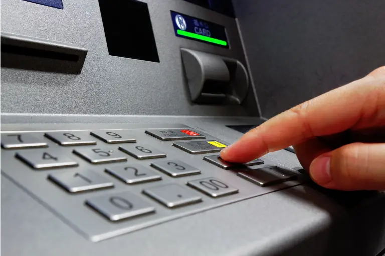 Person pressing button on ATM machine to check RBL Balance 