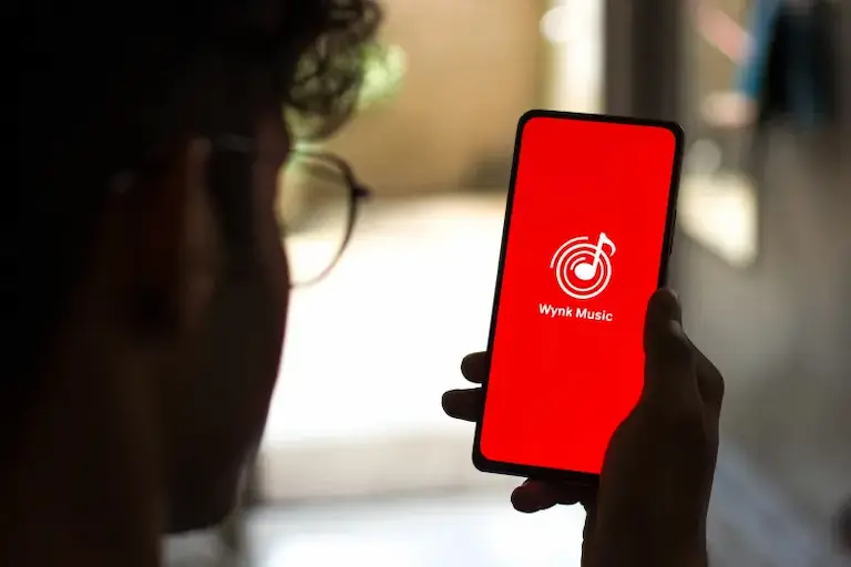 Man opening the wynk app to listen music