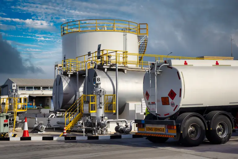 Visual Representation of Fuel Colors A large white tank truck parked on a road, showcasing its sleek design and spacious tank for transporting liquids